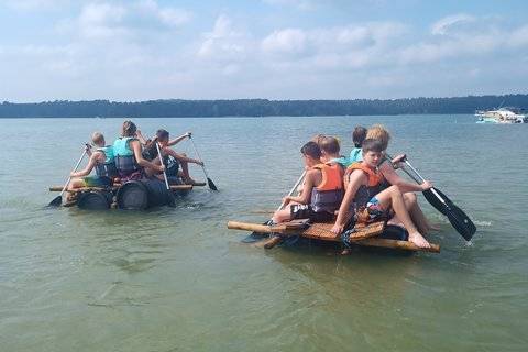 Klassenfahrt Seezeit-Resort Beim teambuilding haben Schüler ein Floß gebaut. Auf dem Bild sehen jeweils sechs Schüler auf zwei selbstgebauten Flößen auf dem Wasser